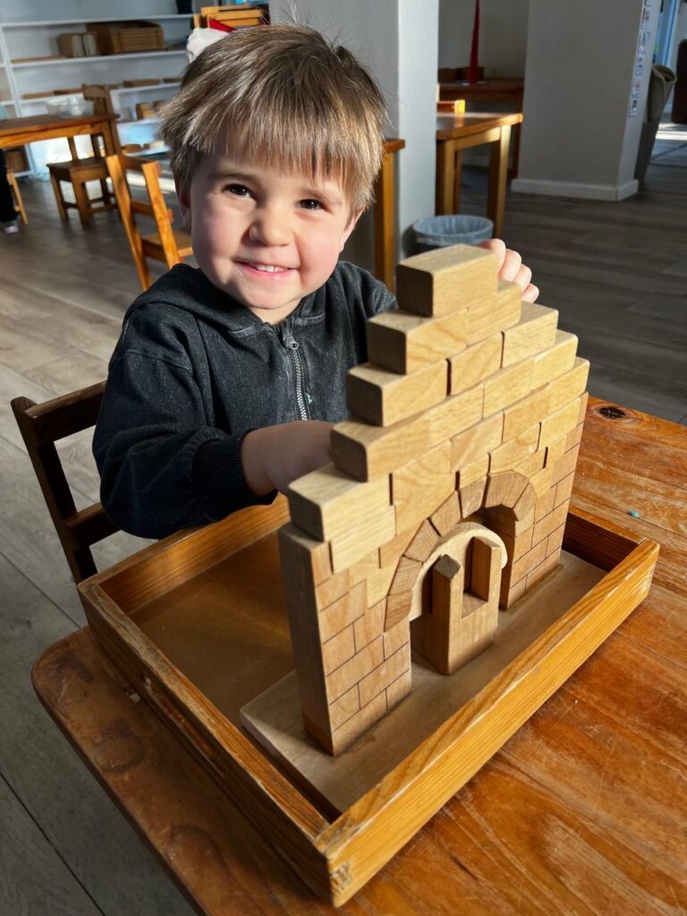 Boy doing Montessori roman arch. 